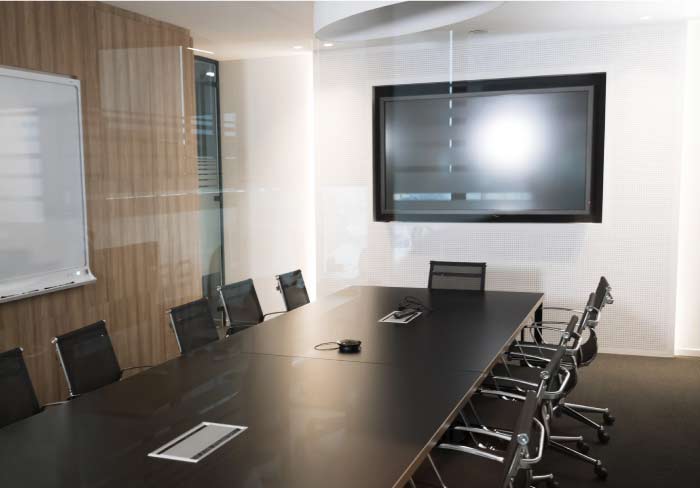 Modern corporate boardroom featuring professional commercial video installation with a large wall-mounted flat screen and integrated conference table connectivity, by the best av company in sacramento, ca